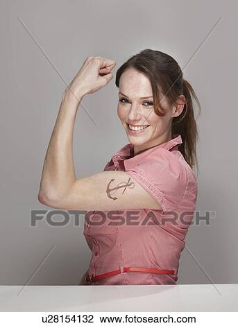 Stock Image - Women with Anchor Tatoo showing Muscle. Fotosearch