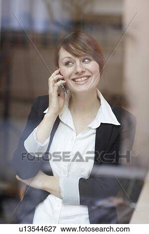 Stock Photo - Women with Cellphone on Window. Fotosearch