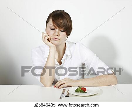 Stock Photography - Women with Salad looking sad. Fotosearch