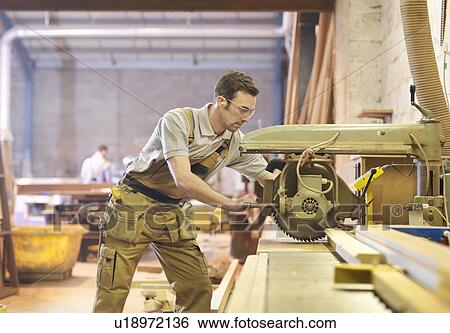 Stock Photograph - Woodworker sawing timber. Fotosearch