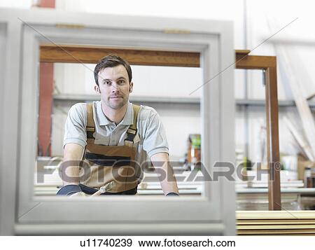 Stock Photo - Woodworker with window frames. Fotosearch