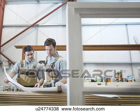 Stock Photo - Woodworkers discussing plans. Fotosearch