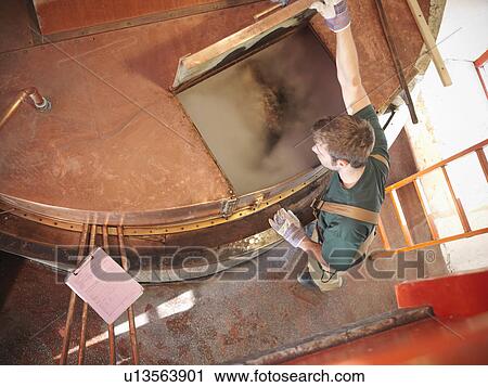 Worker at copper tank in brewery View Large Photo Image Stock Image - Worker at copper tank in brewery. Fotosearch