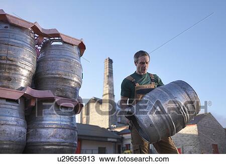 Worker carrying barrel outside brewery View Large Photo Image Stock Image - Worker carrying barrel outside brewery. Fotosearch