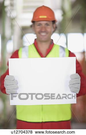Worker holding an empty sheet of paper View Large Photo Image Stock Photo - Worker holding an empty sheet of paper. Fotosearch