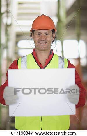 Worker holding an empty sheet of paper View Large Photo Image Stock Photo - Worker holding an empty sheet of paper. Fotosearch