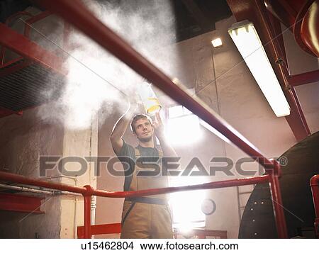 Picture - Worker in brewery inspecting sample. Fotosearch