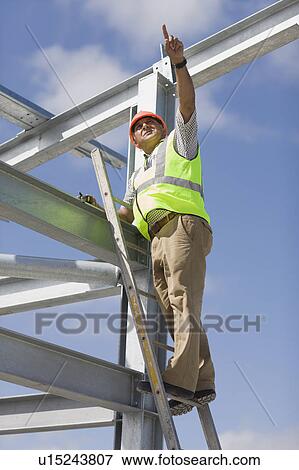 Stock Photo - Worker inspecting the building plot. Fotosearch