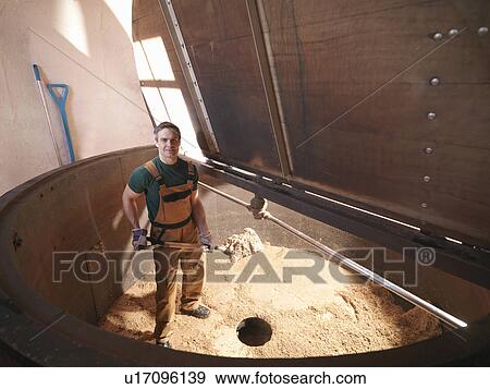 Worker shovelling used hops in brewery View Large Photo Image Stock Photo - Worker shovelling used hops in brewery. Fotosearch
