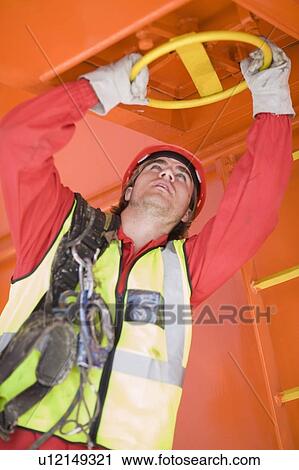 Stock Image - Worker turning a lock. Fotosearch
