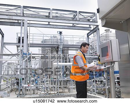 Worker with machinery in bottling plant View Large Photo Image Stock Image - Worker with machinery in bottling plant. Fotosearch