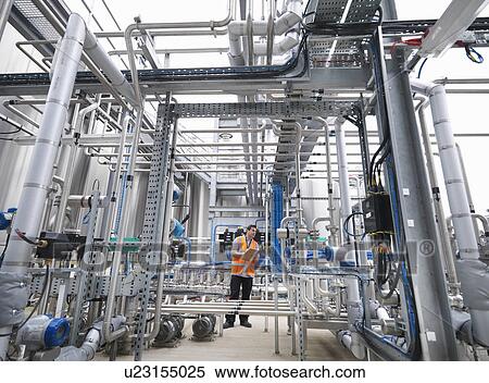 Worker with machinery in bottling plant View Large Photo Image Stock Photography - Worker with machinery in bottling plant. Fotosearch