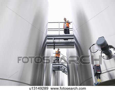 Workers checking tanks in bottling plant View Large Photo Image Stock Photo - Workers checking tanks in bottling plant. Fotosearch