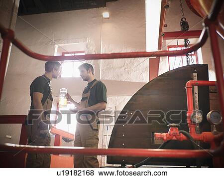 Stock Photo - Workers in brewery with sample. Fotosearch