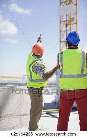 Workers inspecting a building plot View Large Photo Image Stock Photograph - Workers inspecting a building plot. Fotosearch