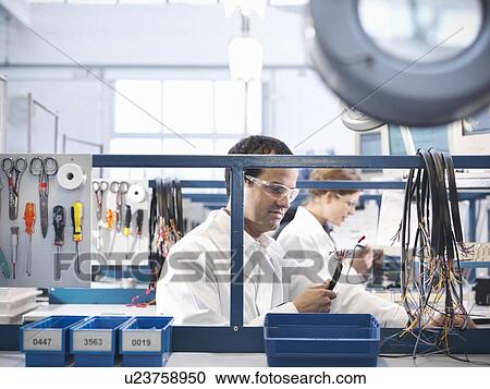 Workers making wiring loom cables View Large Photo Image Stock Image - Workers making wiring loom cables. Fotosearch