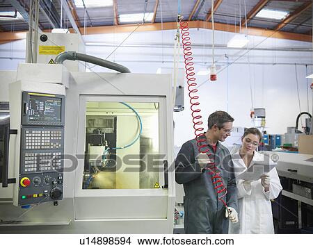 Picture - Workers next to computerised lathe. Fotosearch