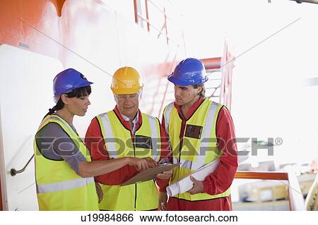 Workers reviewing the following scedule View Large Photo Image Stock Photograph - Workers reviewing the following scedule. Fotosearch