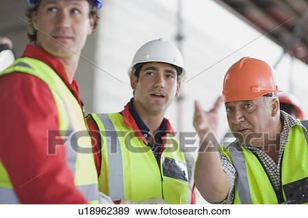Stock Photo - Workers speaking on construction site. Fotosearch