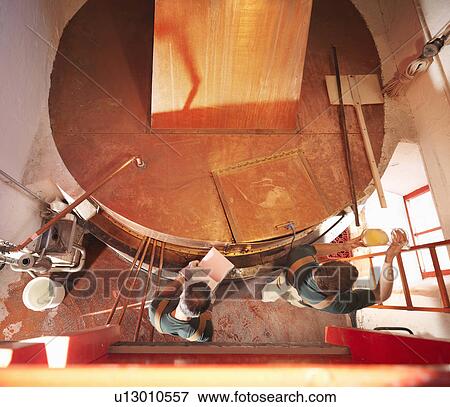 Workers with sample at copper tank View Large Photo Image Stock Photo - Workers with sample at copper tank. Fotosearch