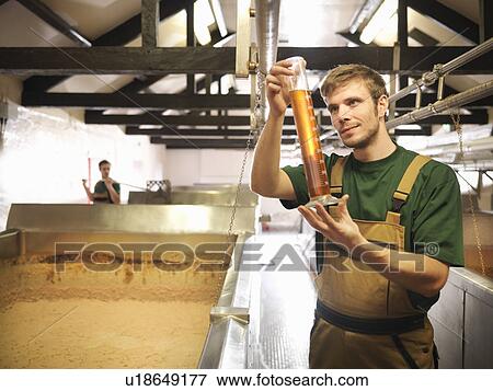 Stock Photo - Workers with sample in fermentation room. Fotosearch