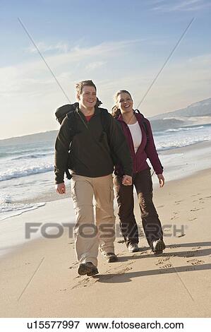 Young backpackers holding hands at beach View Large Photo Image Stock Photo - Young backpackers holding hands at beach. Fotosearch