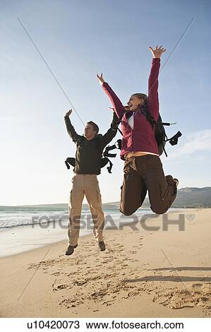 Young backpackers jumping on beach View Large Photo Image Stock Image - Young backpackers jumping on beach. Fotosearch