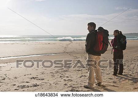 Picture - Young backpacking couple at the beach. Fotosearch