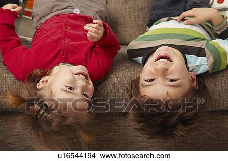 Young boy and girl laughing on sofa View Large Photo Image Picture - Young boy and girl laughing on sofa. Fotosearch