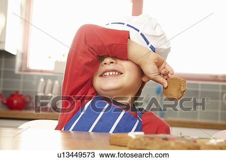 Young boy eating cookie in kitchen View Large Photo Image Stock Image - Young boy eating cookie in kitchen. Fotosearch