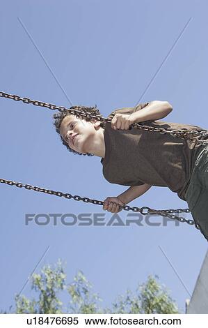 Stock Photography - Young boy on swing. Fotosearch