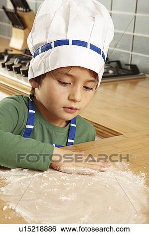 Stock Photograph - Young boy playing with flour on tabletop. Fotosearch