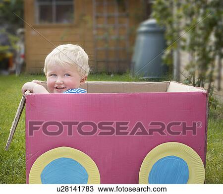 Stock Image - young boy standing in cardboard box. Fotosearch