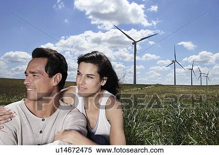Young couple in a field by a wind farm View Large Photo Image Stock Photography - Young couple in a field by a wind farm. Fotosearch