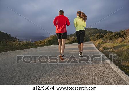 Picture - Young couple jogging in rural setting. Fotosearch