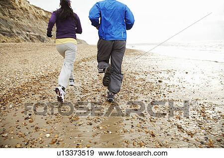 Young couple running by the sea View Large Photo Image Stock Photo - Young couple running by the sea. Fotosearch