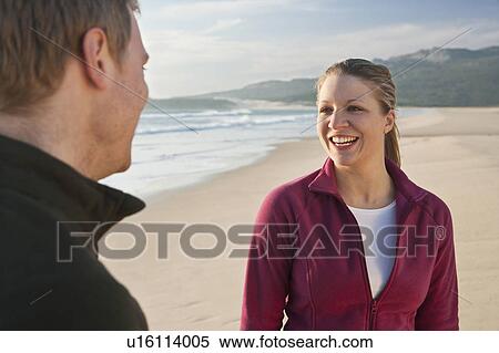 Stock Photography - Young couple smiling on beach. Fotosearch