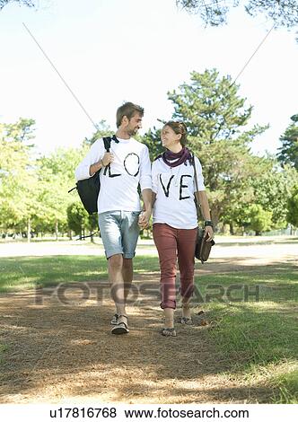 Stock Photo - Young couple walking hand in hand. Fotosearch