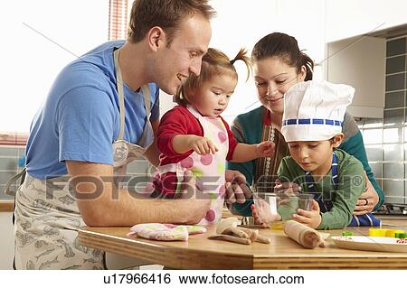 Young family cooking together in kichen View Large Photo Image Stock Photograph - Young family cooking together in kichen. Fotosearch