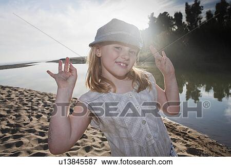 Stock Photo - Young girl at river smiling at camera. Fotosearch