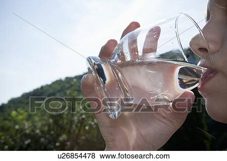 Young girl drinking water close-up View Large Photo Image Stock Photo - Young girl drinking water close-up. Fotosearch