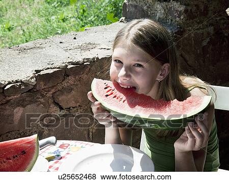 Stock Photo - Young girl eating watermelon. Fotosearch