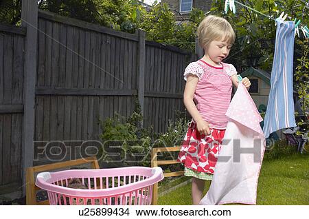 young girl hanging out clothes in garden View Large Photo Image Picture - young girl hanging out clothes in garden. Fotosearch