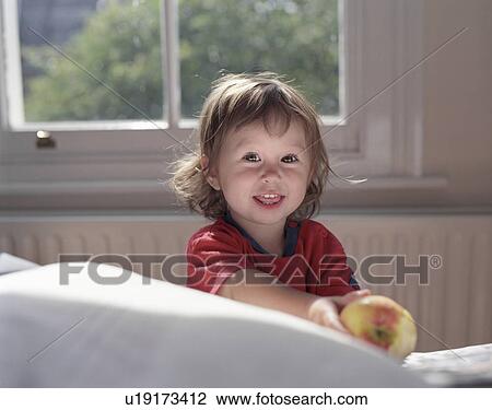 Stock Image - young girl holding apple. Fotosearch