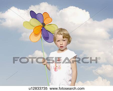 Stock Photography - young girl holding toy windmill. Fotosearch