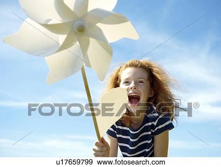 Stock Photo - Young girl laughing with windmill. Fotosearch