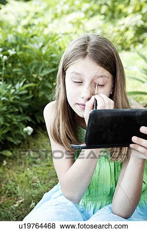 Young girl playing with make-up View Large Photo Image Stock Photo - Young girl playing with make-up. Fotosearch