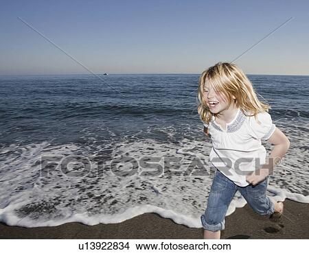 Picture - Young girl running on beach. Fotosearch