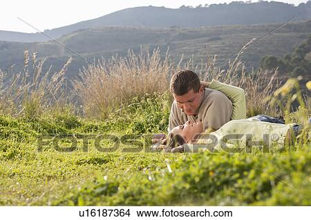 Young loving couple lying in field View Large Photo Image Picture - Young loving couple lying in field. Fotosearch