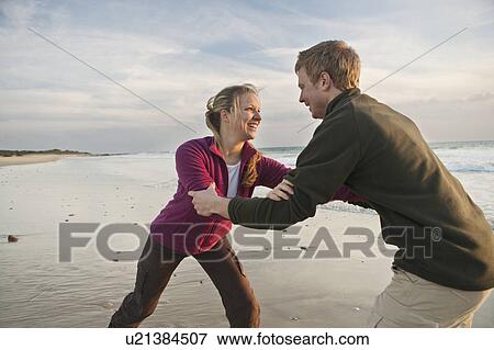 Young man and woman wrestling at beach View Large Photo Image Stock Photo - Young man and woman wrestling at beach. Fotosearch